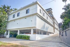 a white building with a staircase leading up to it at HOTEL CASON INTERNATIONAL in Kondotti