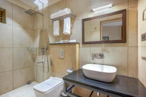 a bathroom with a sink and a toilet and a mirror at HOTEL CASON INTERNATIONAL in Kondotti