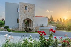 a villa with a view of a house with flowers at Luxury Villa Majore in Svoronata