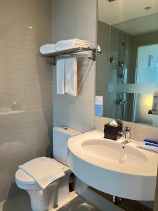 a bathroom with a sink and a toilet and a mirror at Holiday Inn Express Jakarta International Expo, an IHG Hotel in Jakarta