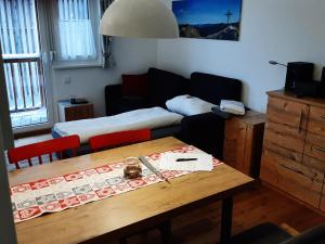 a living room with a table and a bed at Apartment Bella in Turracher Hohe