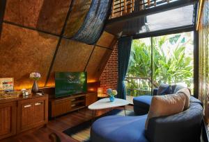 uma sala de estar com duas cadeiras azuis e uma televisão em LA COCOTTE VILLA & FARM KHAO YAI em Nong Sarai