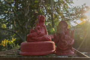 un grupo de estatuas sentadas sobre una mesa en SaffronStays Doon Garden Villa - near Doon School and Mall Road en Dehradun