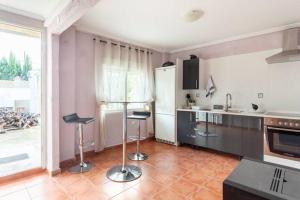 a kitchen with two stools in the middle of a room at Casita Rural CANTONAL in Valencia