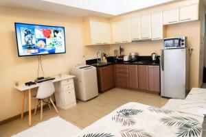 a kitchen with a refrigerator and a desk in a room at A2J Luxury Venice Studio Suite Near BGC Malls in Manila