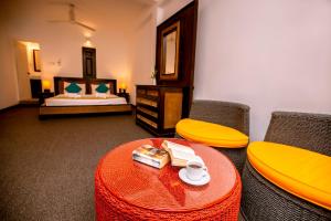 a room with a table and two chairs and a bed at St.Lachlan Hotel & Suites in Negombo