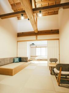 a room with a bed and two chairs in it at SATOYAMA STAY Nino-Machi in Furukawachō