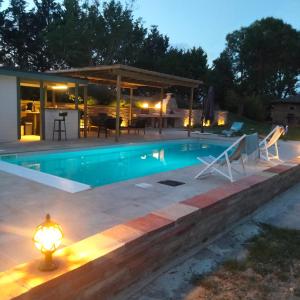 a swimming pool with a patio and a house at Chambres d'Hôtes Le Loubet in LʼIsle-Jourdain
