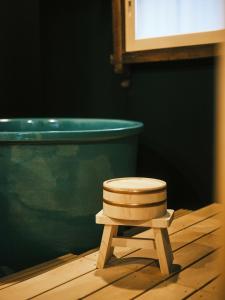 a wooden stool sitting in front of a bath tub at SATOYAMA STAY Nino-Machi in Furukawachō