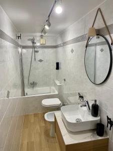 a bathroom with a sink and a toilet and a tub at Two Balcony Central Bari in Bari