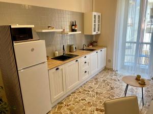 a kitchen with a white refrigerator and a table at Two Balcony Central Bari in Bari