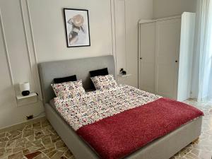 a bedroom with a bed with a red blanket and pillows at Two Balcony Central Bari in Bari