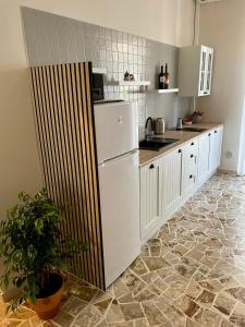 a kitchen with a white refrigerator and a tile floor at Two Balcony Central Bari in Bari