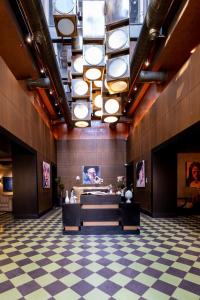 a lobby with a checkered floor and a large ceiling with lights at Root Karaköy in Istanbul