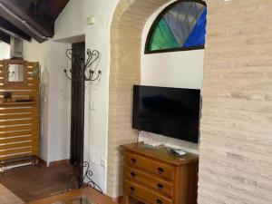 een woonkamer met een tv en een glas-in-loodraam bij Buhardilla de Wallada Córdoba in Córdoba