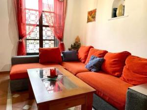 een woonkamer met een oranje bank en een salontafel bij Buhardilla de Wallada Córdoba in Córdoba