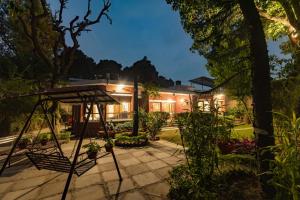 una casa con jardín por la noche en SaffronStays Doon Garden Villa - near Doon School and Mall Road en Dehradun