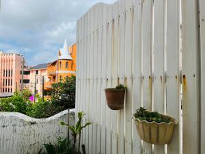 een wit hek met twee potplanten erop bij Xing Yu Inn in Eluan