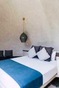 um quarto com uma cama grande e almofadas azuis e brancas em Panorama Beach Club & Resort em El Nido