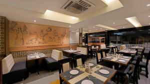 Hotel Ekaa Keys By Rivido - Hosur Main Road, Kudlu Gate في بانغالور: غرفة طعام مع طاولات وكراسي في مطعم