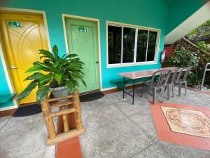 SibulanにあるSea Forest Resortのテーブルと椅子と黄色のドアのある家