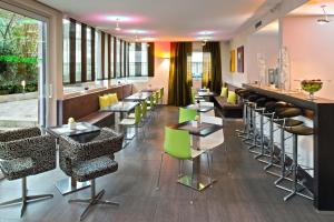 a restaurant with tables and chairs and a bar at Hotel Mainstation in Frankfurt/Main