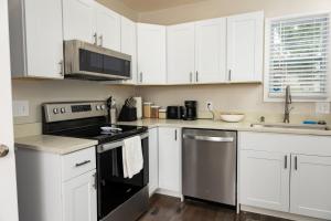 a kitchen with white cabinets and stainless steel appliances at Newly renovated home less than a mile from downtown Roanoke in Roanoke