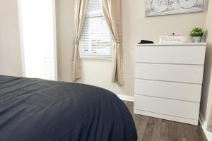 a bedroom with a chest of drawers and a window at Newly renovated home less than a mile from downtown Roanoke in Roanoke