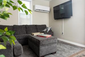 sala de estar con sofá y TV en Newly renovated home less than a mile from downtown Roanoke, en Roanoke