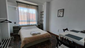 1 dormitorio con cama, mesa y ventana en Pensión Benavente AP-7 3 min - Playa 5 min coche, en Moncófar