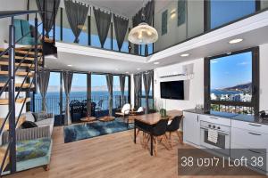 a large living room with a staircase and a living room with a view at YalaRent La Mera- Suits Hotel with Sea of Galilee views in Tiberias