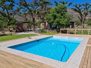 a swimming pool with blue water in a yard at Crocodile Sands River Lodge in Nelspruit