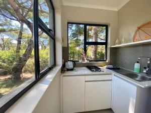 a kitchen with white cabinets and a large window at Crocodile Sands River Lodge in Nelspruit