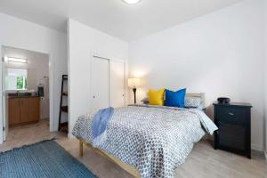 una camera da letto con un letto con cuscini blu e gialli di Surf Park Place a Garden City