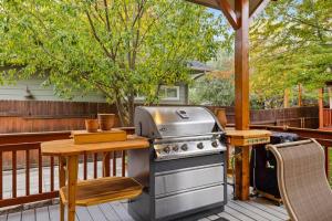 a grill on a deck with a wooden table and a table at Marshall Street Music Retreat in Boise