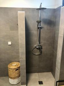 eine Dusche mit einer Glastür und einem Korb in der Unterkunft Studio Kooka nui - Private apartment in Papeete