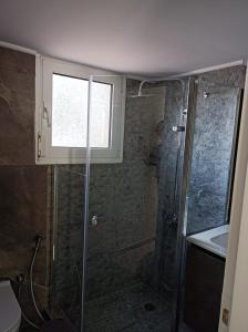 a bathroom with a shower with a window and a sink at Full Acropolis View Apartment in Athens