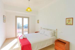 1 dormitorio con cama blanca y ventana en Villa Kalamia en Kalámi