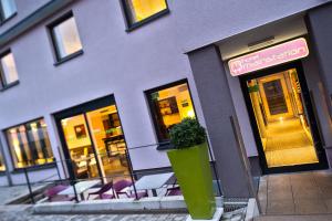 a building with chairs and a potted plant in front of it at Hotel Mainstation in Frankfurt/Main