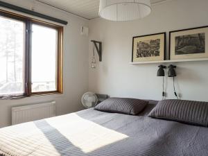 1 dormitorio con cama y ventana grande en Holiday home BRASTAD XIV, en Brastad