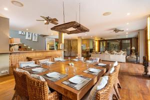 a dining room with a large wooden table and chairs at Villa Yoga in Seminyak