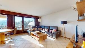 una sala de estar con un sofá y una mesa en Lovely apartment with a view - accessible by skis, en Crans-Montana 21 fotos más