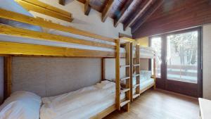 Un dormitorio con dos literas y una ventana. en Lovely apartment with a view - accessible by skis, en Crans-Montana