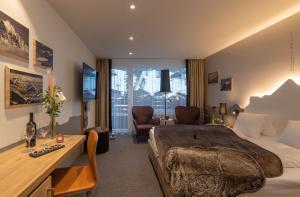 een hotelkamer met een bed en een bureau bij Sunstar Hotel & SPA Grindelwald in Grindelwald