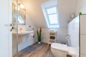 baño con aseo y lavabo y ventana en Nordseeperle, en Greetsiel