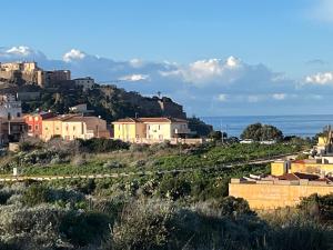 a town on a hill with houses and the ocean at Owen Home Holiday in Castelsardo