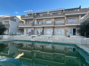 a building with a swimming pool in front of it at Owen Home Holiday in Castelsardo