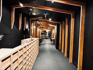 a restaurant with a long corridor with tables and chairs at Namba Guesthouse HIVE in Osaka