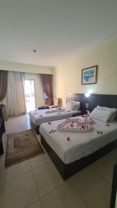 een hotelkamer met drie bedden met bloemen erop bij Uni sharm aqua park in Sharm El Sheikh