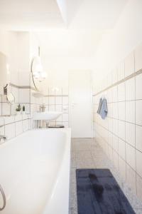 Baño blanco con bañera y lavamanos en CenterApartment, WIFI, SmartTV, full Kitchen, Netflix, Pottbude in Essen en Essen